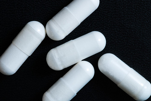 Close-up of white pills on a black surface